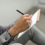 person writing on laptop